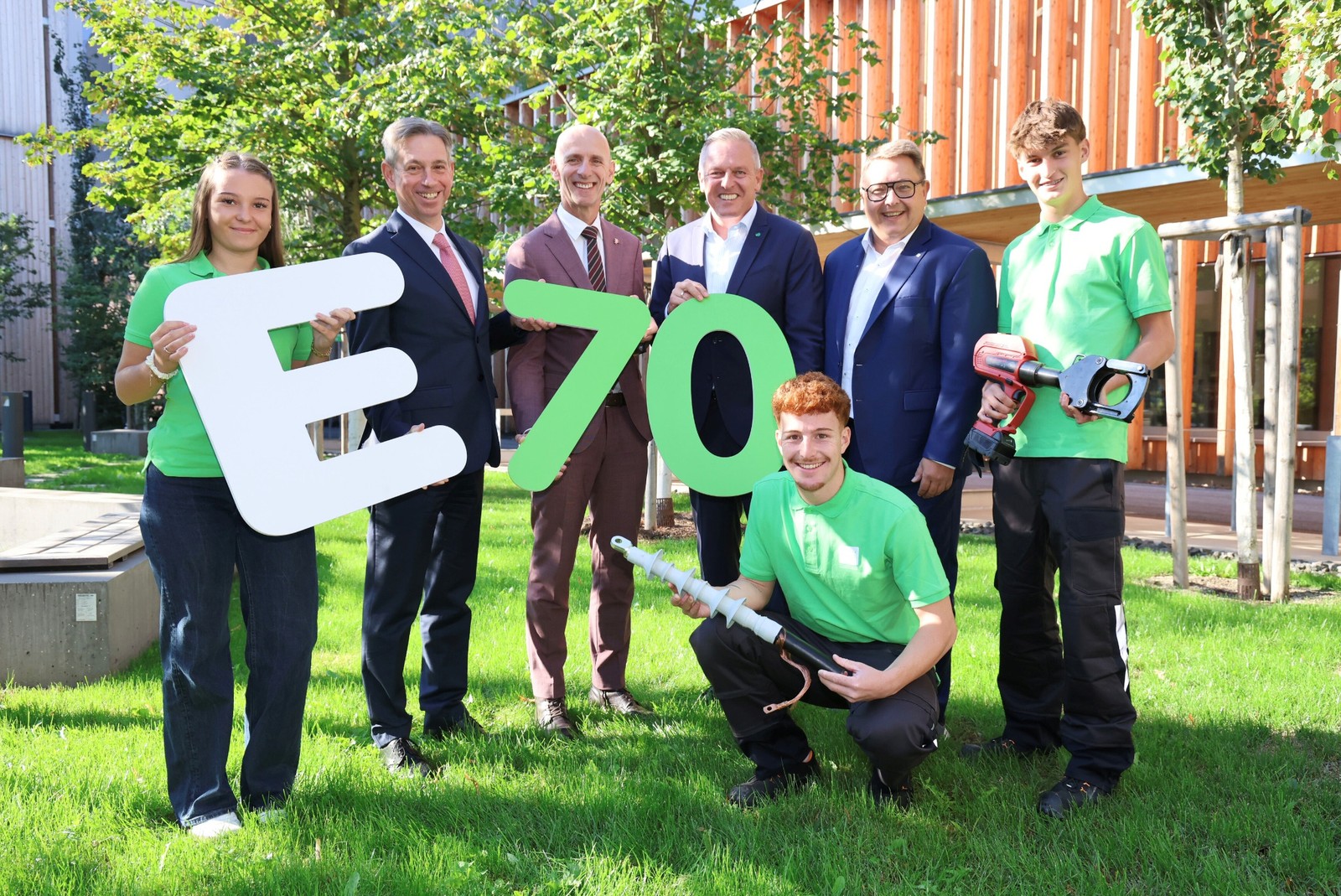 Drei Lehrlinge, zwei Vorstände und zwei Landespolitiker beim Jubiläum der Energie Steiermark mit einem großen E und der Zahl 70.